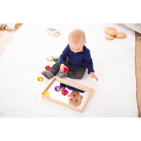 A compact wooden tray with a mirrored base, perfect for sensory play, loose parts exploration, and visual perception activities.