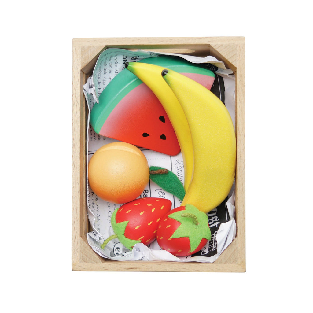 Wooden crate of colorful toy fruits, including bananas, strawberries, orange, and a watermelon slice. Bright, playful, and neatly arranged.