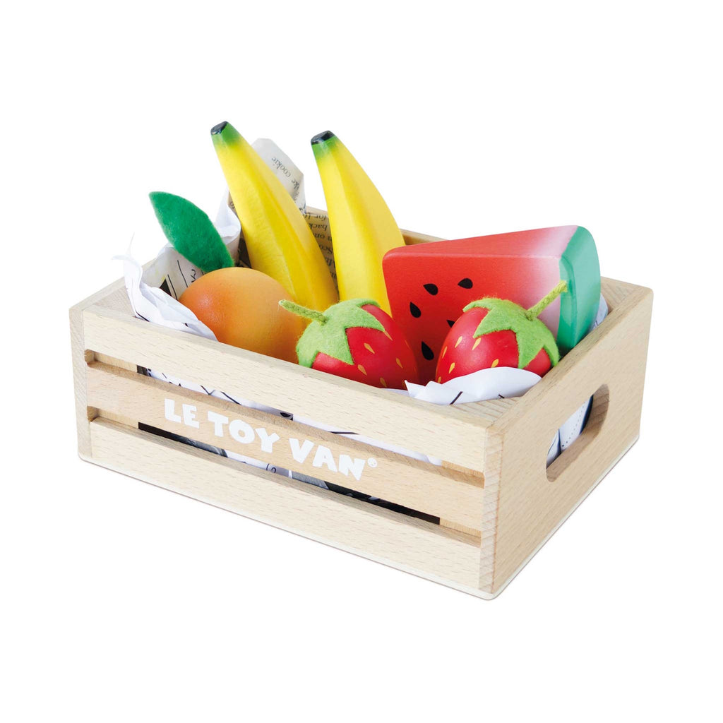 Wooden crate of colorful toy fruits, including bananas, strawberries, orange, and a watermelon slice. Bright, playful, and neatly arranged.