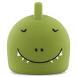 Cute green dino lamp with a round body and a small horn on top, featuring a large, smiling mouth with tiny teeth and shut eyes, exuding a playful vibe.