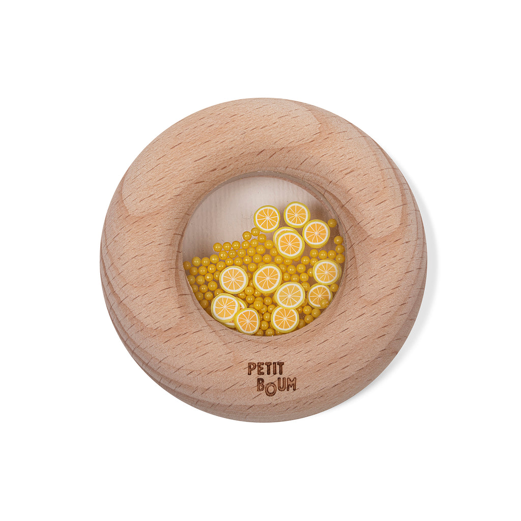 Petit Boum sensory donut in lemon design, featuring a wooden ring with a clear window filled with yellow beads and lemon slice decorations