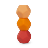 Three geometric, dodecahedron-shaped blocks stacked vertically. Colors progress from peach at the top, to orange in the middle, and red at the bottom.