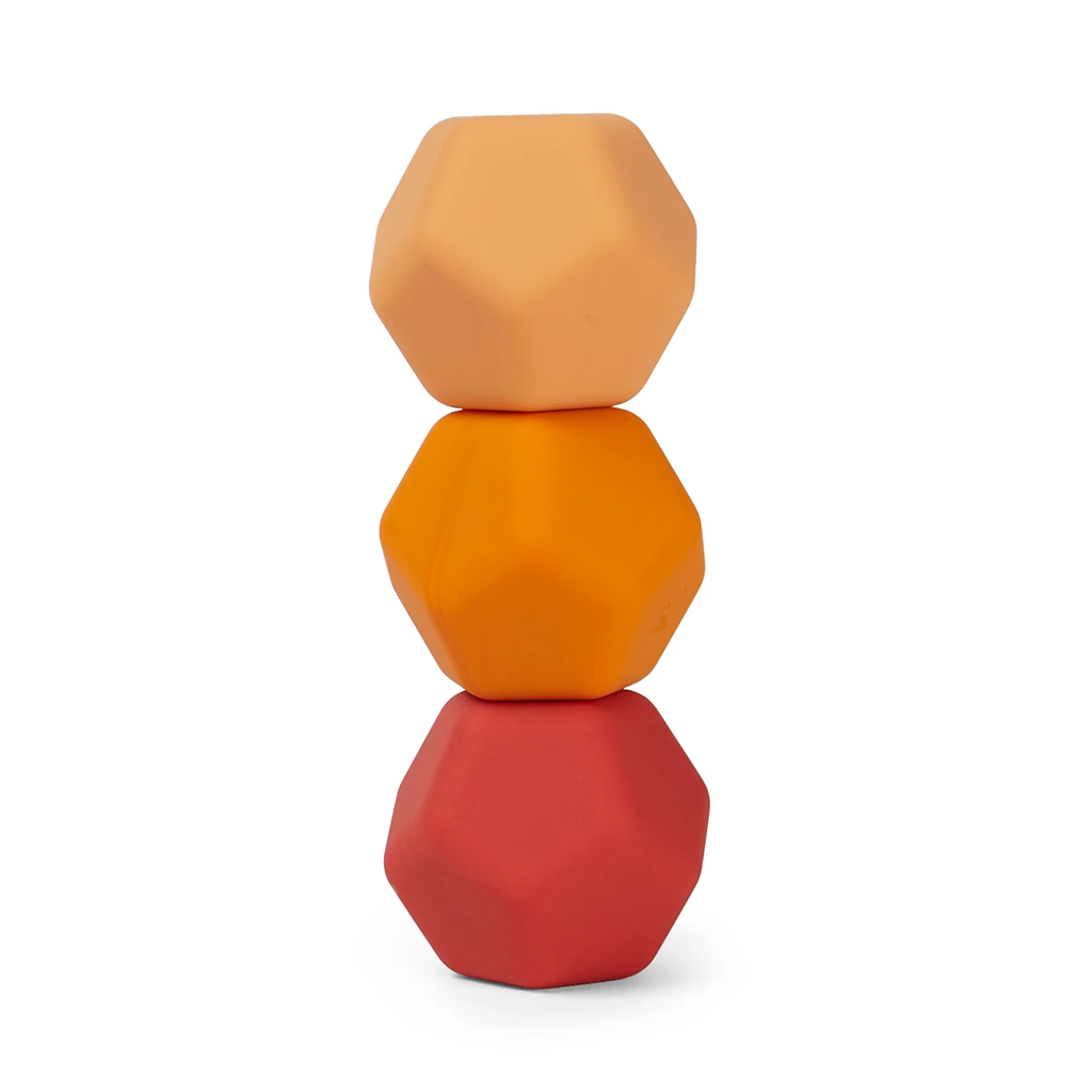 Three geometric, dodecahedron-shaped blocks stacked vertically. Colors progress from peach at the top, to orange in the middle, and red at the bottom.