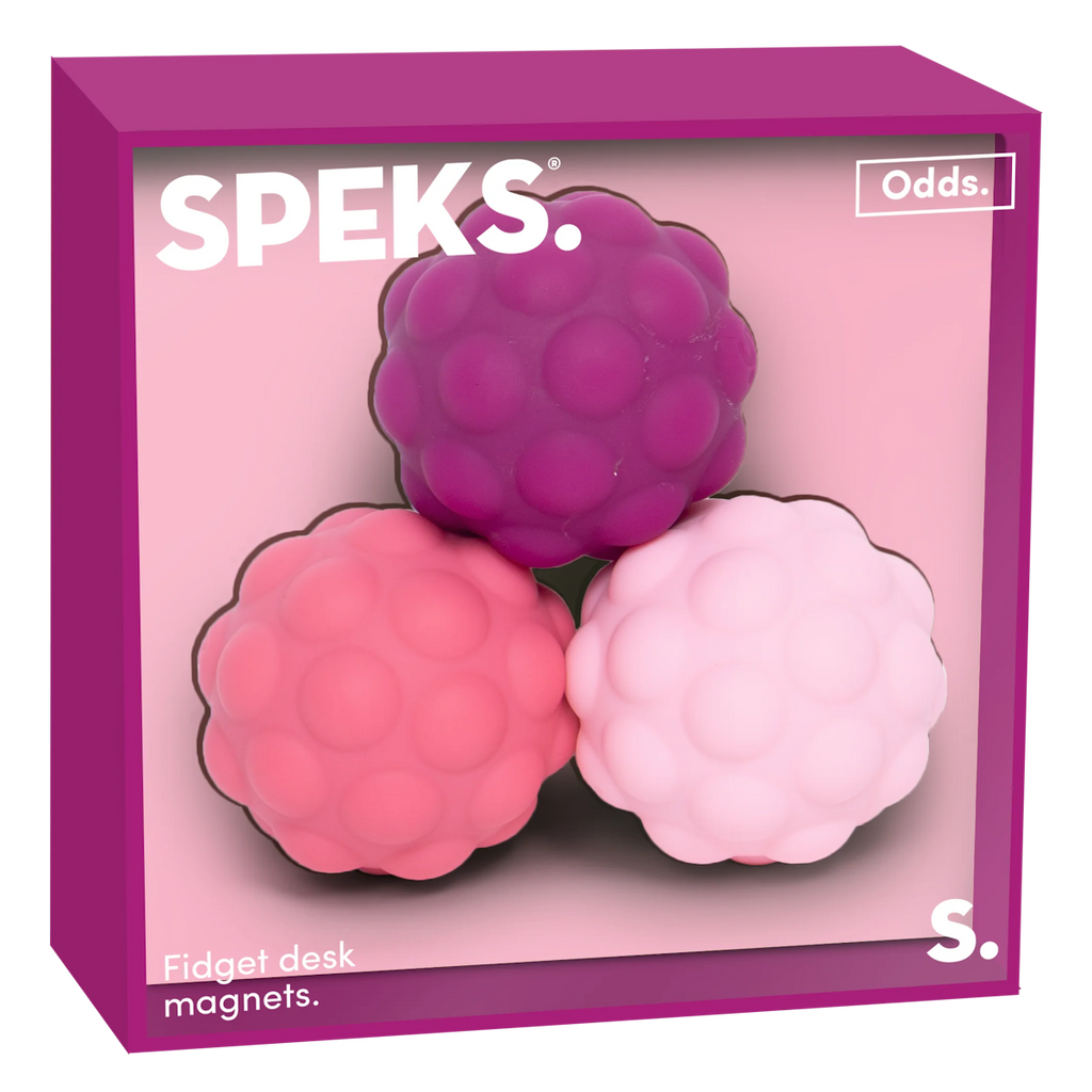 Three textured, round fidget desk magnets in purple, pink, and light pink are placed in a magenta box labeled "Speks Odds." The tone is playful.