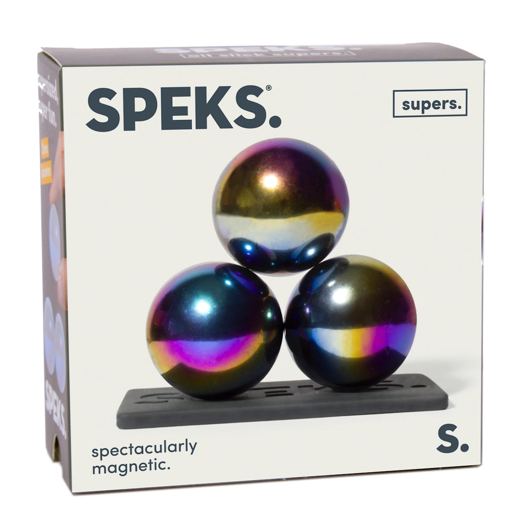 Packaging of "Speks Supers" showcasing three glossy, iridescent magnetic spheres stacked in a triangular formation on a black base. Text reads "Spectacularly Magnetic."