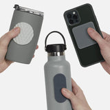 Three hands holding items with silicone sensory stickers on a grey travel mug, bottle, and phone.