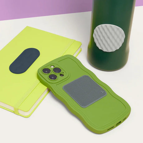 Green water bottle, notebook, and phone case, each featuring different silicone sensory stickers.