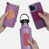 Hands holding purple items with textured silicone sensory stickers attached.