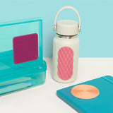 Textured silicone sensory stickers placed on a water bottle, pencil box, and notebook.
