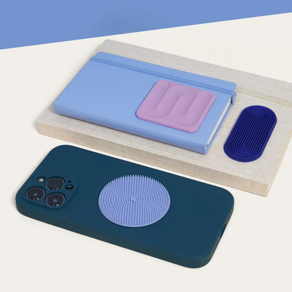 Textured silicone sensory stickers placed on a phone case, notebook, and book.