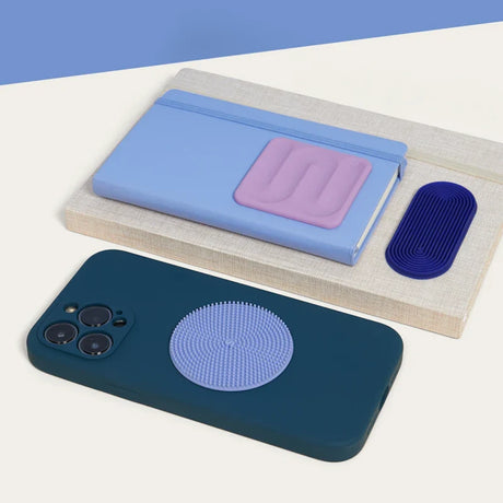 Textured silicone sensory stickers placed on a phone case, notebook, and book.