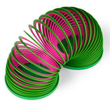 A colorful plastic slinky toy is coiled, showing alternating green and pink bands. The toy forms arches, creating a playful, dynamic visual effect.
