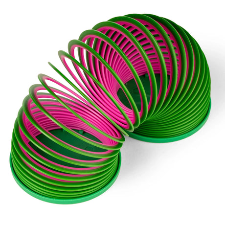 A colorful plastic slinky toy is coiled, showing alternating green and pink bands. The toy forms arches, creating a playful, dynamic visual effect.