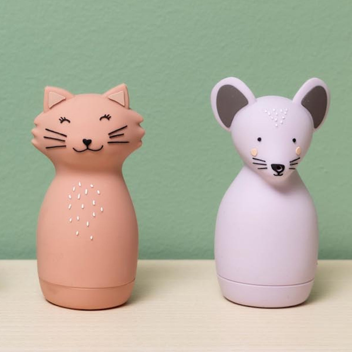 Pink cat and purple mouse silicone squeezy animal toys for kids on a wooden surface.