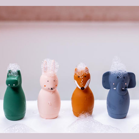 Four colorful animal-shaped bottles, crocodile, rabbit, fox, elephant, adorned with soap bubbles on top, set against a light background. Playful and whimsical.