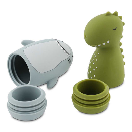 Blue shark and green dinosaur silicone travel containers with their screw-top lids removed.