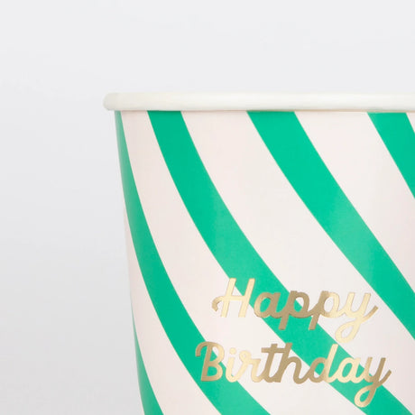 Close-up of a green and white striped paper cup with "Happy Birthday" in gold script.