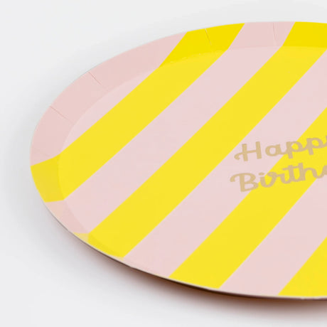 A pink and yellow striped paper plate with "Happy Birthday" written on it.
