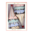 A box of Meri Meri pastel striped party hats with scalloped edges and red pom-poms.