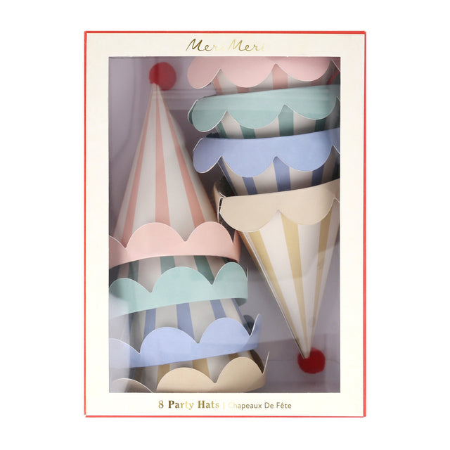 A box of Meri Meri pastel striped party hats with scalloped edges and red pom-poms.