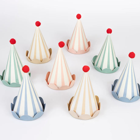 Eight striped pastel party hats with red pom-poms arranged on a white background.
