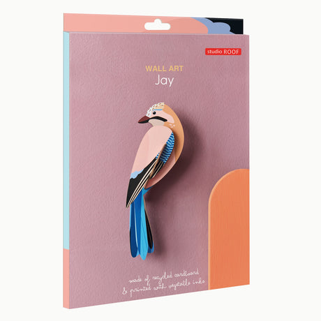 Pink and blue jay wall art made from recycled cardboard on a mauve background. Text reads "Wall Art Jay" and "Printed with vegetable inks."