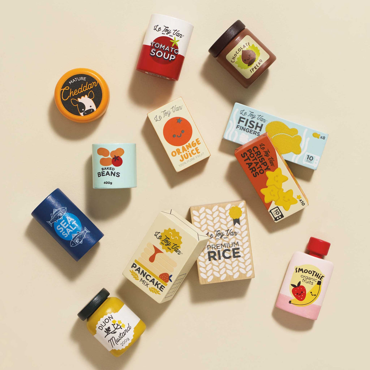 Top-down view of wooden toy grocery items scattered across a beige background.