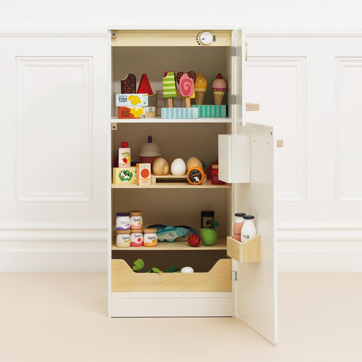 Open white wooden toy fridge stocked with colorful play food and drinks.