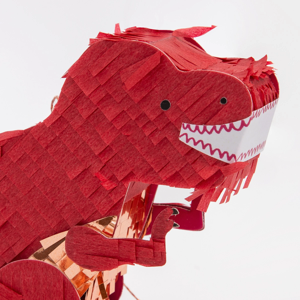 A mini dinosaur-shaped piñata in green with colorful streamers, perfect for party favors or small treats.