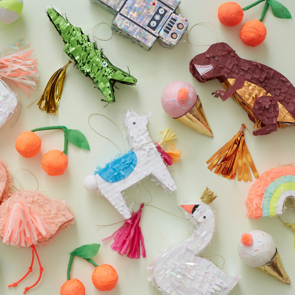 A mini dinosaur-shaped piñata in green with colorful streamers, perfect for party favors or small treats.