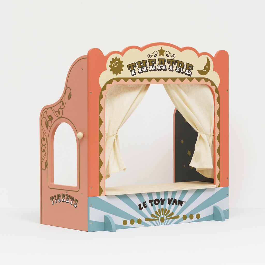 A colorful wooden toy puppet theater with cream curtains closed. The top reads "Theatre" in bold letters, conveying a playful and creative mood.