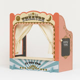 Vintage-style wooden tabletop puppet theatre with fabric curtains and a chalkboard side sign.
