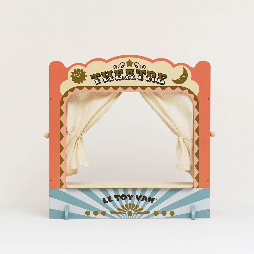 A colorful wooden toy puppet theater with cream curtains closed. The top reads "Theatre" in bold letters, conveying a playful and creative mood.
