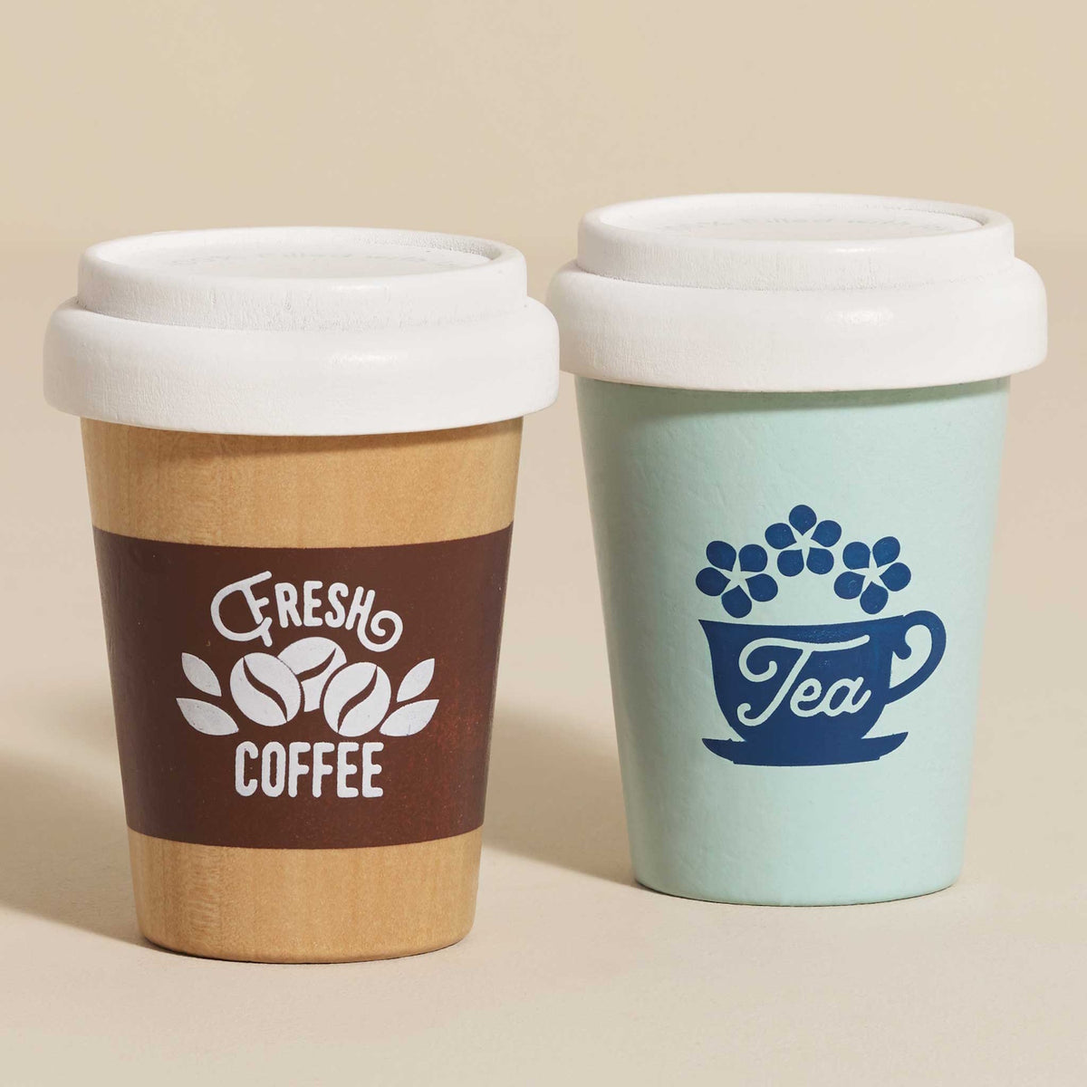 Two wooden play eco-cups labeled Fresh Coffee and Tea with white lids on a neutral surface.