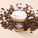 Wooden toy coffee cup labeled Fresh Coffee surrounded by scattered roasted coffee beans.