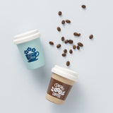 Top-down view of wooden play Tea and Fresh Coffee cups with coffee beans scattered between them.