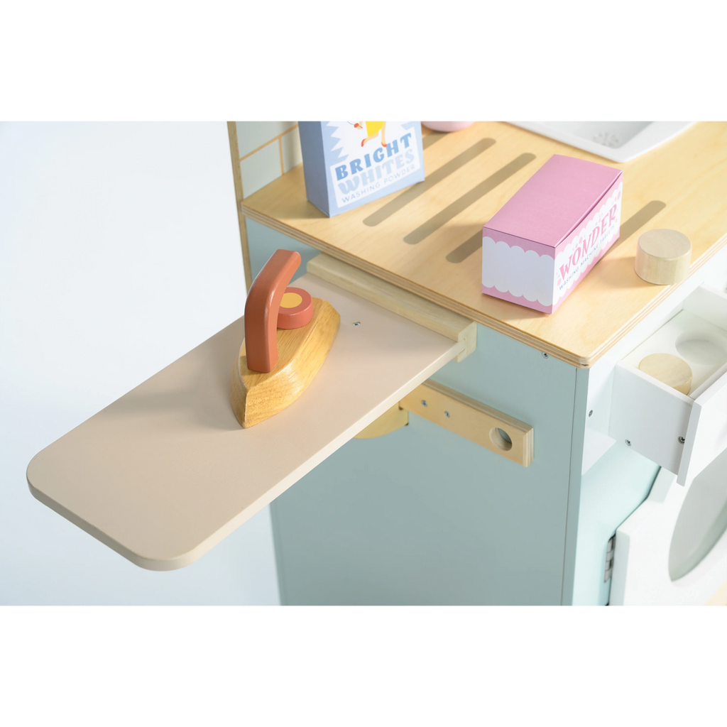 Wooden play set featuring a miniature washing machine, ironing board, and laundry accessories for imaginative role play and tidy-up fun.