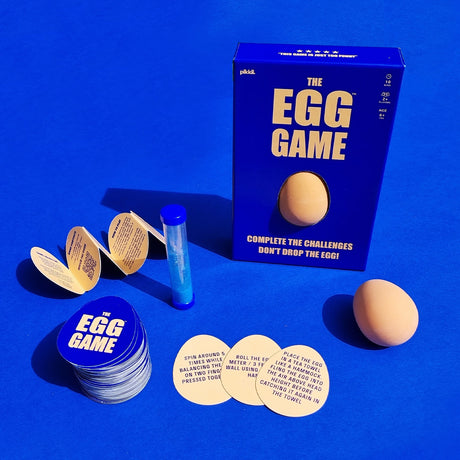 "The Egg Game" box displayed with toy egg, hourglass, folded instructions, and egg-shaped cards.