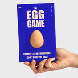 A hand holding the blue box for "The Egg Game" by pikkii featuring a 3D egg in the center.