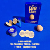 The Egg Game box displaying contents: fake egg, sand timer, instructions, and challenge cards.