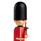 Toy soldier figurine with a British guard uniform, featuring a tall black hat and red coat, holding a rifle. The backdrop is solid white.