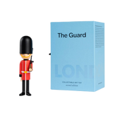 Toy soldier figurine in red uniform and tall black hat stands next to a light blue box labeled "The Guard," evoking a London theme.