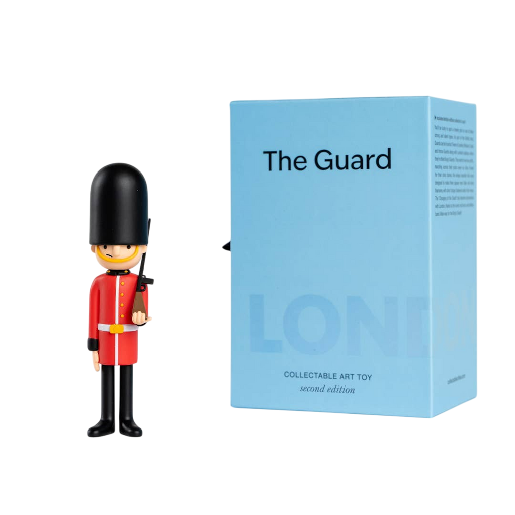 Toy soldier figurine in red uniform and tall black hat stands next to a light blue box labeled "The Guard," evoking a London theme.