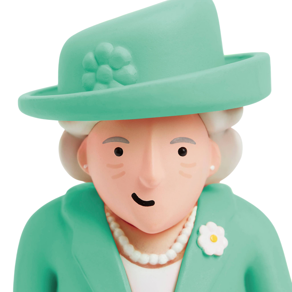 A cartoon-style figure with a simple face, wearing a turquoise outfit and matching hat. The figure has a neutral expression and wears a pearl necklace.