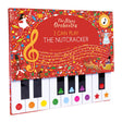 Children's book cover with a toy piano keyboard. The red theme features festive illustrations from "The Nutcracker," including ballerinas and musical notes.