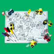 Coloring mat with vehicles, road signs, and markers scattered on a vibrant green background.