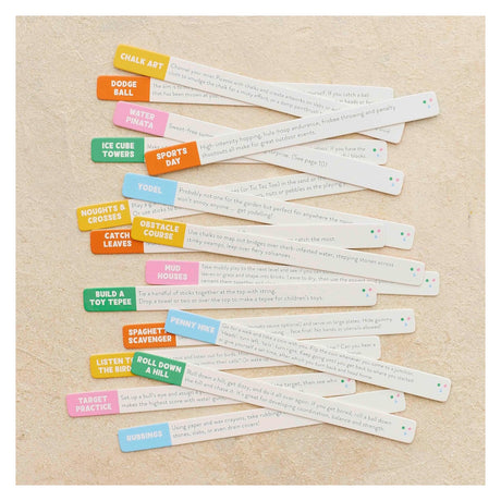 Colorful activity sticks with printed outdoor play prompts, including "Roll Down a Hill" and "Penny Hike."