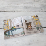 Open fabric book displaying illustrations of a frog by a pond and a deer with a fawn.