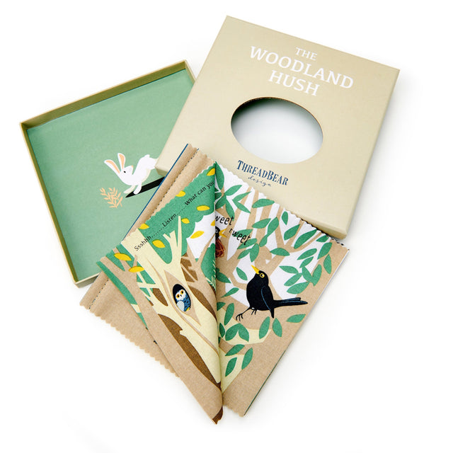"The Woodland Hush" fabric book displayed next to its original beige box and green lid.
