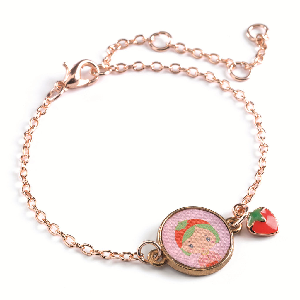 A children's bracelet from Djeco's Tinyly collection featuring a gold-colored chain and a charm of Berry, a character depicted with a strawberry accessory.